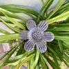 Daisy flower design on a wrought iron garden spike.