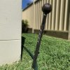 Wrought iron garden spike protects corner of a building.